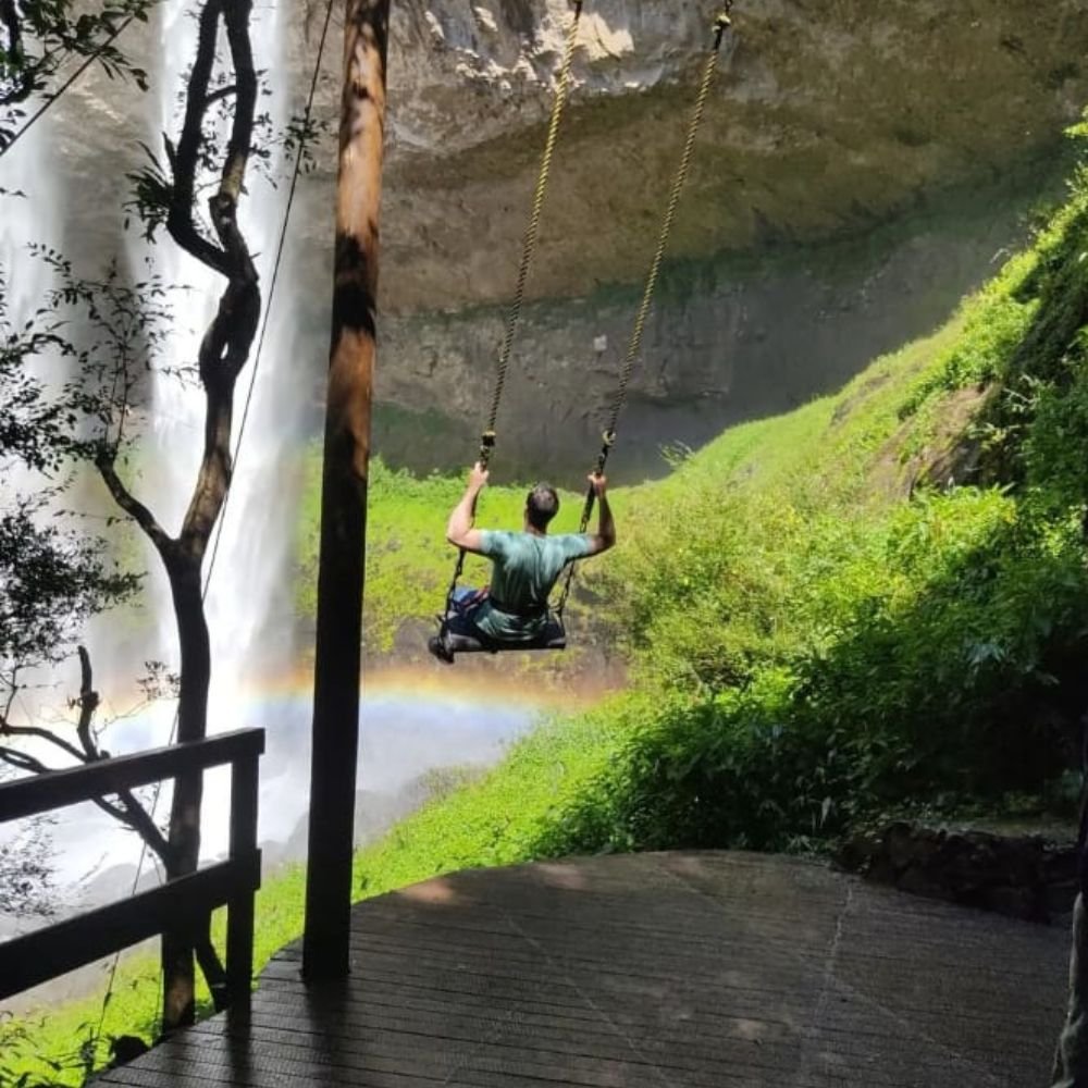 Balanço de frente com cachoeira e arco íris